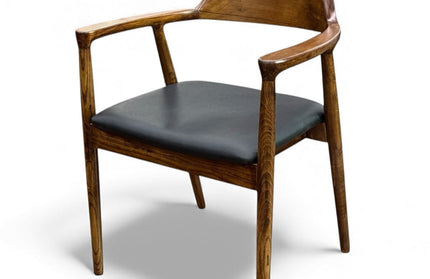 Wooden chair with black cushion on a white background